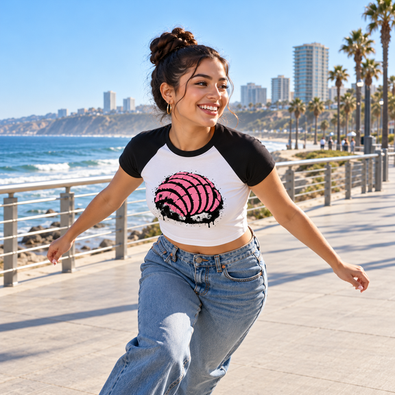 Model roller-skating at the Tijuana waterfront in the white and black Concha Rosa Baby Tee [Color: White with Black]